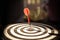 Close up red color arrow in the center of Bullseye with dark background concept of business goal