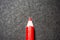 Close up of a red coloured pencil colour, with black background.