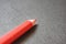 Close up of a red coloured pencil colour, with black background.