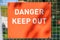 Close up of a red danger keep out sign in bright sunny sunlight