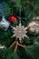 Close up of red dauble hanging from a decorated christmas tree