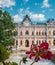 Close up of red flowers over the Manuc Bei mansion background. An architectural, culture and historic complex and museum, at