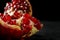 A close-up of a red garnet. A bittersweet pomegranate on a black background. A pomegranate full of juicy, fres