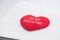 Close up red heart pillow with be my valentine word lying on bed