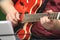 Close-up of a red jazz guitar with the musician\'s fingers moving. Full figured musician with his fat instrument.