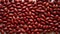 Close up of red kidney beans evenly scattered on table. Top view. Background texture of uncooked kidney beans. Copy