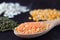 Close-up red lentils in wooden spoon on a black background