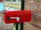 A close up of the red mailbox  Stuck at the front of the house  Mailing concept.