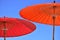 Close-up of a red and orange parasol umbrella against the blue sky