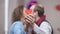 Close-up of red paper heart in male and female hands with blurred adult couple kissing at background. Loving happy man