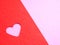 Close up, Red paper, punching in a heart shape, placed on pink paper for the background of your text.