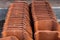 Close-up of red pile of roof tiles stacked on the ground