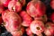 Close up of red ripe pomegranates in a basket during autumn harvest, whole fresh and organic food for a healthy diet