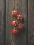 Close up of red tomatoes on dark rustic wooden background. Seasonal healthy summer vegetable.Top view