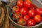 Close up of red tomatoes in a green bowl and slices of bread