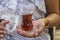 Close-up of red Turkish tea with traditional pear shaped glass in the woman hand, Turkey