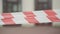 Close-up of red and white barricade tape with blurred urban building at the background. City institution closed for