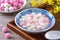 Close up of red and white tangyuan in blue bowl on wooden background for Winter solstice