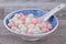 Close up of red and white tangyuan in blue bowl on wooden background for Winter solstice