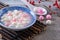 Close up of red and white tangyuan in blue bowl on wooden background for Winter solstice