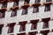 CLOSE UP: Red windows of Potala Palace overlook the scenic Tibetan landscape.