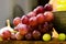 Close up of a red and yellow muscat grape in a cup on a wooden board