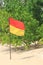 Close up of a red and yellow safety flag on an idyllic beach