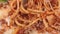 Close-up reeling appetizing fresh spaghetti bolognese with parmesan with tomato sauce using fork
