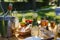 Close up of refreshing drinks at summer garden party. Table setting with glasses, lemonade and bottles of summer wine.