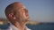 Close-up religious Caucasian man praying in sunshine on picturesque Mediterranean sea beach in sunshine. Young handsome