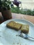 Close up remaining of sliced toasted bread with butter and sweetened condensed milk on white dish after full