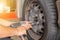 Close up of repair mechanic hands during maintenance work to pneumatic gun to loosen a wheel nut changing tyre of car