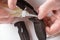 Close-up on repairman`s hands lubricating a pocket knife with household oil