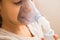 Close up. Respiratory diseases. The child`s face in the process of inhalation with a nebulizer. Clinic, treatment.