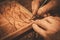 Close-up of restorer hands working with antique decor element in his workshop