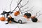 Close up retro toy car with Halloween pumpkins, gifts over tree branches. Creepy and funny decorations concept.