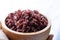 Close-up. Riceberry rice in a wooden bowl