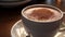 A close-up of a rich, velvety cup of hot cocoa with a dusting of cocoa powder in