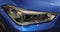 Close up of right front headlight of the blue luxurious sport ca