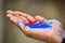 Close up of ring jewelry on human hand with vibrant holi multi colors powder. Selective focus on friendship ring. Happy festival