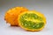 Close-up of a ripe Kiwano or Horned Melon fruit, sliced length-wise on white background