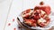 close-up, ripe pomegranates on a brown ceramic bowl on a white wooden table