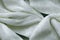Close-up of rippled white natural fur silk fabric texture background. Suede leather chamois delicate fabric textile