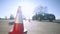 Close-up of road cone outdoors in sunlight with blurred driving instructor walking to car at background. Professional