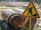 Close-up road sign - repair works on the road, large diameter pipes for replacement