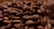 Close-up roasted coffee beans dropping