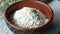 Close up of roasted oats flakes in wooden bowl on table