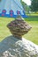 Close up rock cairn sits near an Indian Tee-Pee.