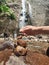 Close up of rock formations with Dolo waterfall in the background in Kediri Regency, East Java, Indonesia