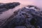 Close-up of rocks and water. Moody purple sunrise. Long exposure image of water